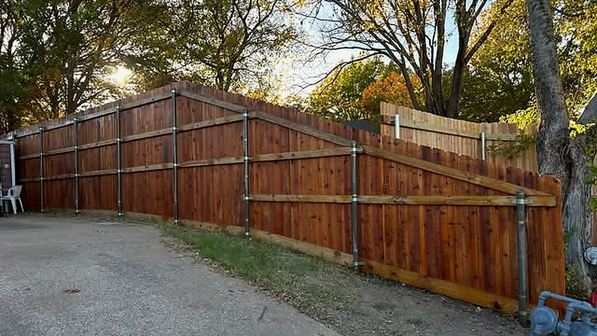 A custom cedar privacy fence stepped down a sloped yard, built by RAMZ Custom Fencing in Arlington, Texas.